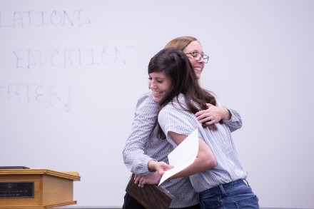 An Ed.D. faculty member gives a student a congratulatory hug