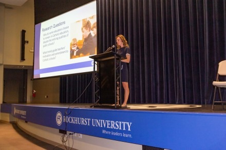 A female doctorate of education student gives a presentation in Arrupe Auditorium