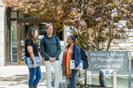 Three graduate students talking in front of Conway Hall
